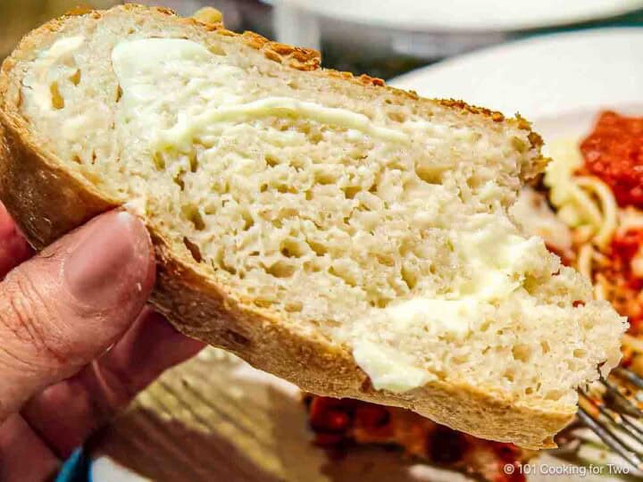 Peasant bread with butter over a plate.